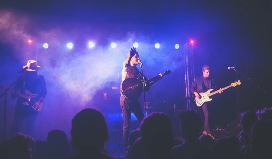 Musicians play on stage at the House of Blues, with vibrant lights and smoke creating an energetic atmosphere in Myrtle Beach.