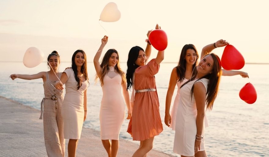 Friends celebrating a Myrtle Beach bachelorette party with balloons on the beach at sunset