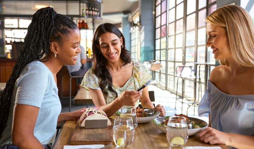 Friends enjoying a casual meal while planning a Myrtle Beach bachelorette party itinerary