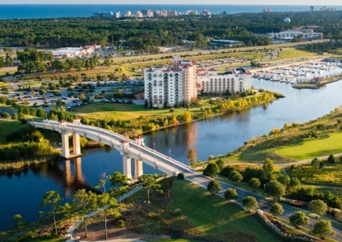 Aerial view of a large waterfront resort with a bridge and marina.