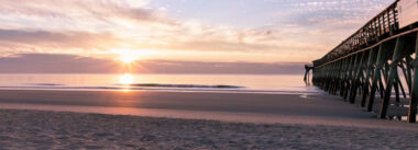 Serene beach sunrise over the ocean and pier during the peaceful Myrtle Beach Off-Season