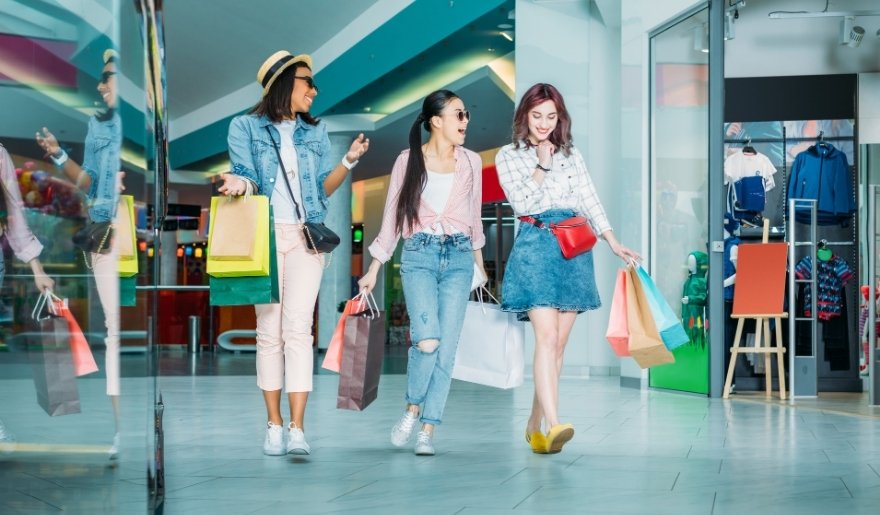 Friends carrying shopping bags while exploring stores during a Myrtle Beach shopping trip