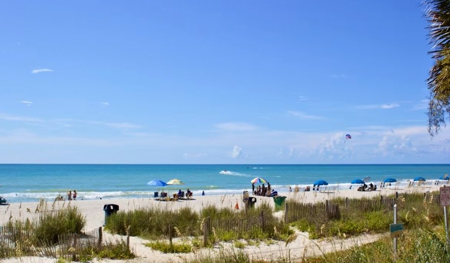 Sunny October weather at Myrtle Beach with beachgoers, blue skies, and ocean views
