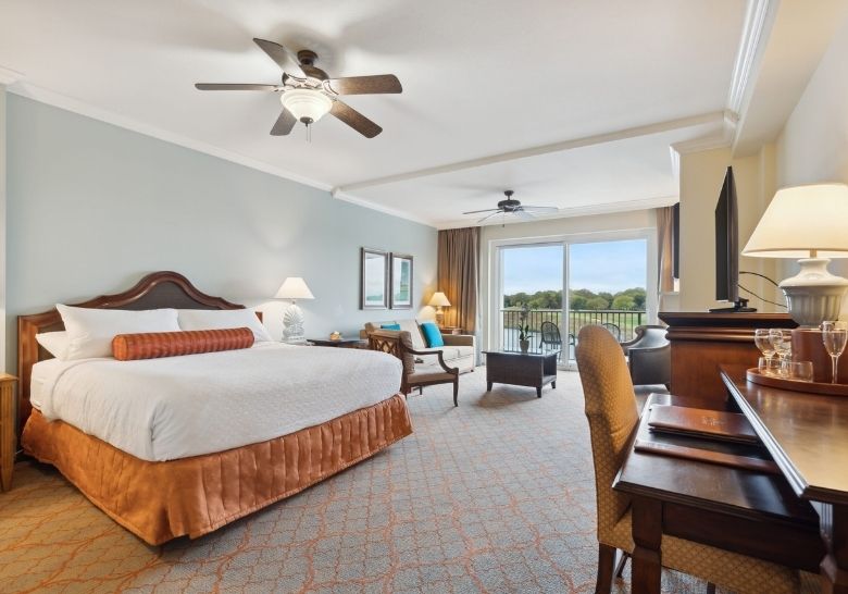 Spacious Marina Inn suite with king bed, sitting area, and balcony view