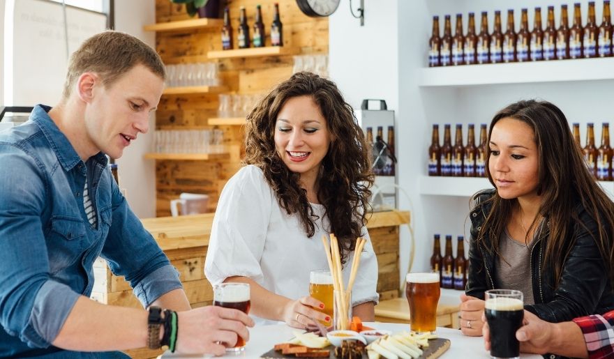 Friends enjoying craft beer and snacks at a local Myrtle Beach brewery during winter.