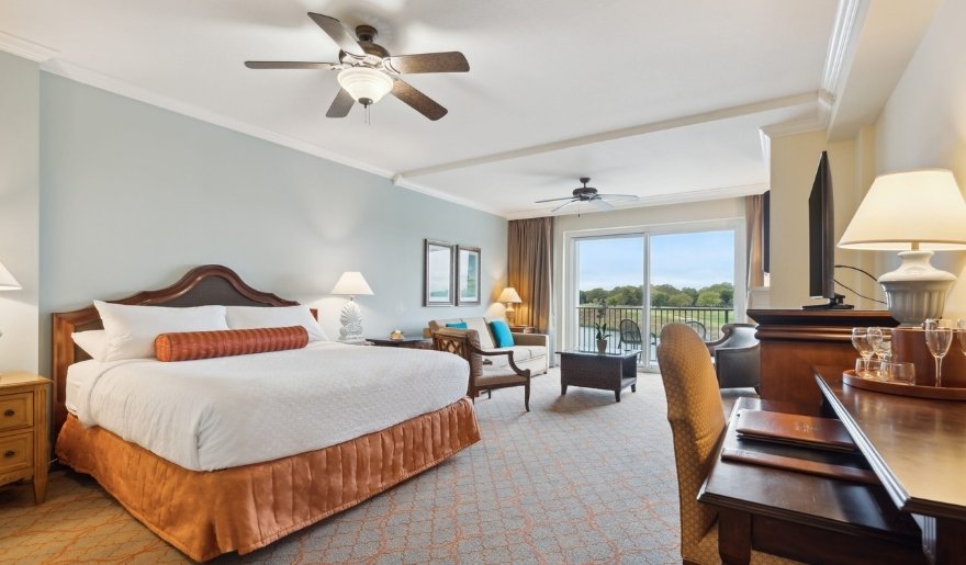 Spacious guest room at Marina Inn at Grande Dunes with king bed, seating area, and balcony.