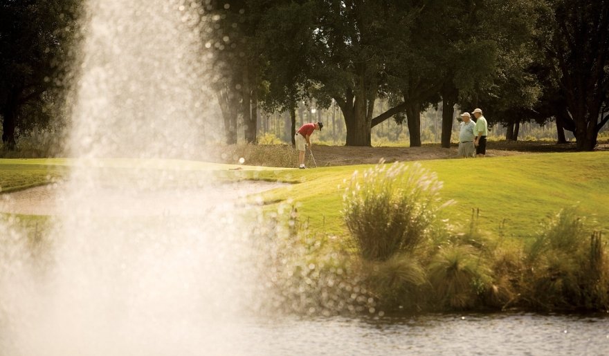 Myrtle Beach golf course in December with golfers enjoying a scenic green and tranquil water views.