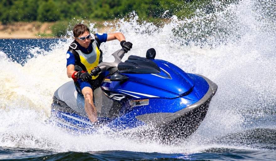 Man riding a jet ski through ocean waves while enjoying watersports in Myrtle Beach.